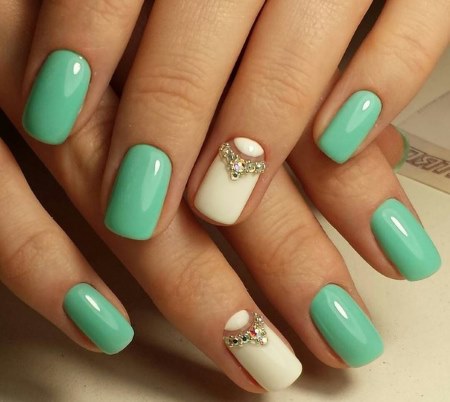 Manucure à la menthe. Design en argent, avec strass, vernis gel. Une photo