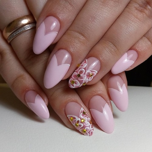 Francês em unhas amendoadas. Desenhos elegantes com strass, brilhos, buracos, fricção, padrões delicados. Uma foto