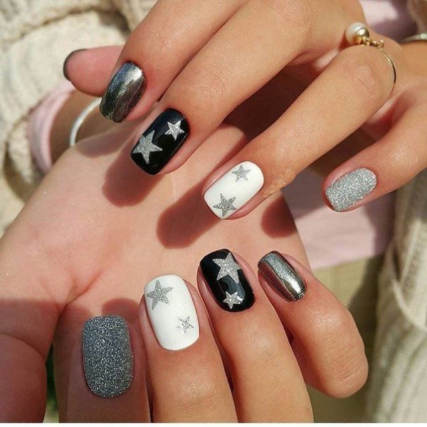 Conception d'ongles en noir et blanc. Photo de nouveaux articles avec strass, argent, veste de service, or, motif