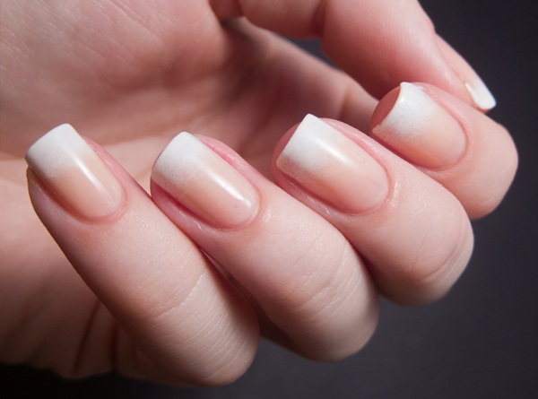 Manicure em tons de marrom-bege. Foto com um padrão, com strass para unhas curtas e compridas