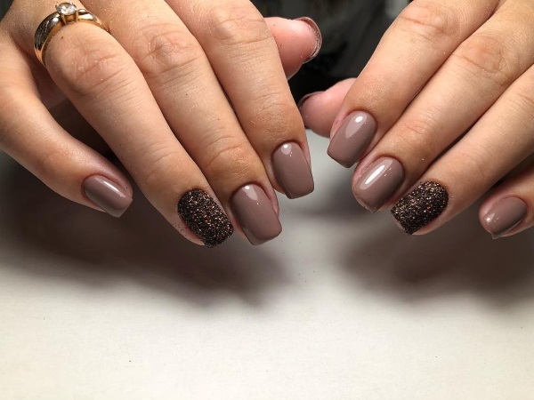 Manicure em tons de marrom-bege. Foto com um padrão, com strass para unhas curtas e compridas