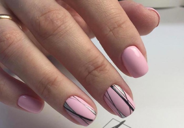 Desenhos de unhas de manicure nas cores rosa. Foto com uma imagem, strass, brilhos