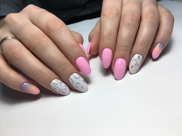 Desenhos de unhas de manicure nas cores rosa. Foto com uma imagem, strass, brilhos