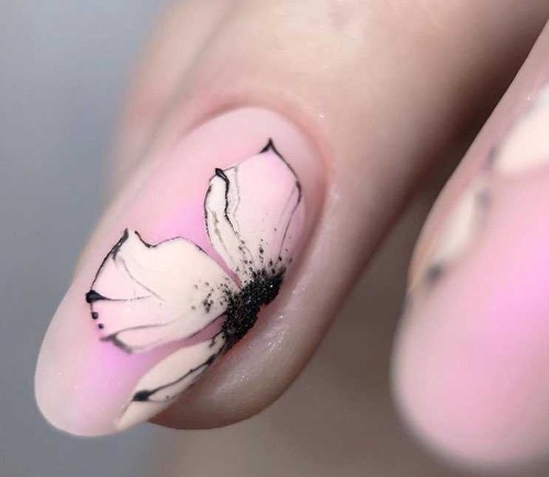 Desenhos de unhas de manicure nas cores rosa. Foto com uma imagem, strass, brilhos