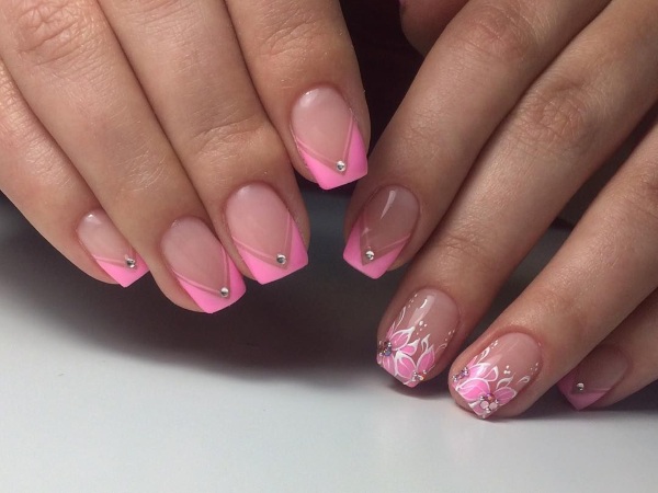 Desenhos de unhas de manicure nas cores rosa. Foto com uma imagem, strass, brilhos