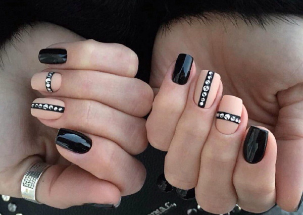 Bege com desenho de unhas pretas. Foto com um padrão, renda, fosco para unhas curtas