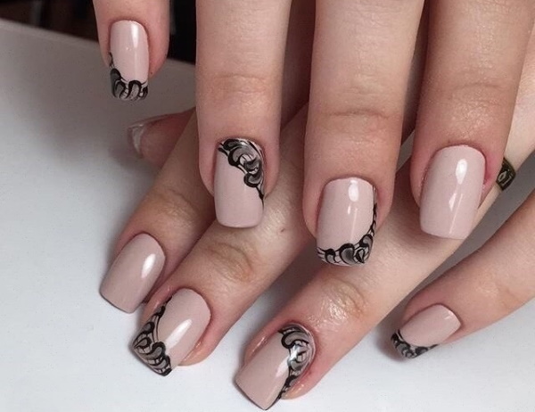 Bege com desenho de unhas pretas. Foto com um padrão, renda, fosco para unhas curtas