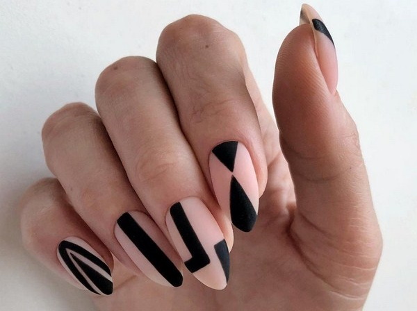 Bege com desenho de unhas pretas. Foto com um padrão, renda, fosco para unhas curtas