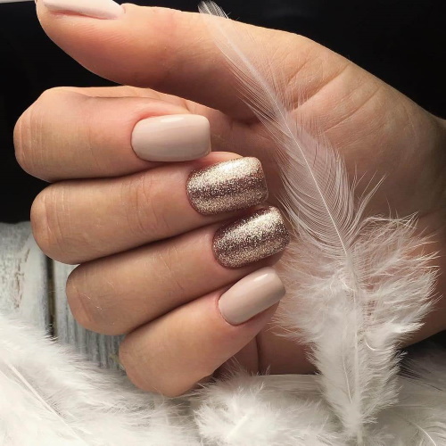 Manicure bege com brilhos, strass nas unhas curtas na base, fricção, estampa. Uma foto