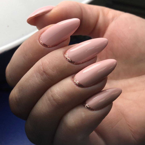 Manicure bege com brilhos, strass nas unhas curtas na base, fricção, estampa. Uma foto