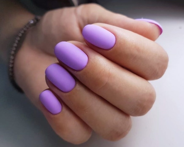 Conception des ongles lilas. Photo avec strass, violet avec des fleurs, motif