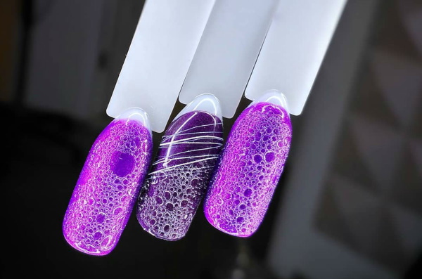 Conception des ongles lilas. Photo avec strass, violet avec des fleurs, motif