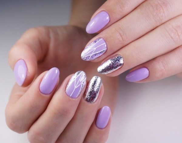 Conception des ongles lilas. Photo avec strass, violet avec des fleurs, motif