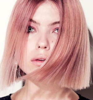 Cabelo loiro quente. Foto com raízes escuras, tonalidade rosa, tinta