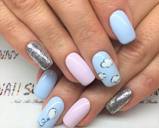 Manicure com nuvens, brilhos, arco-íris, rosa, azul. Uma foto