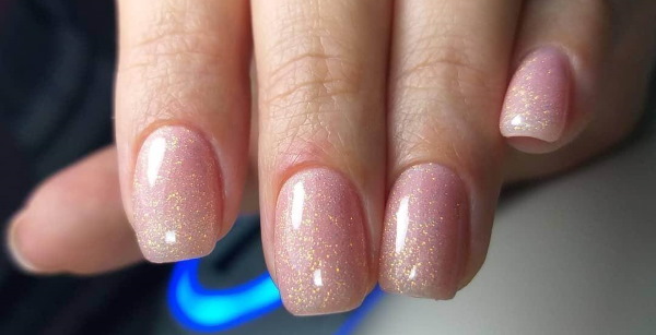 Camuflagem de manicure com lantejoulas. Foto de unhas lunares curtas e compridas, com strass, estrias