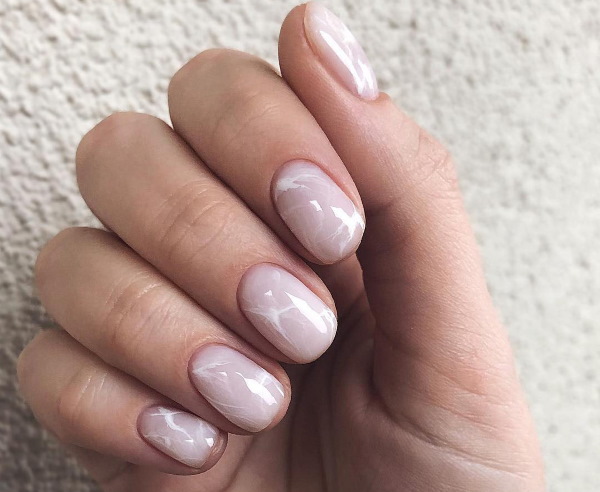 Camuflagem de manicure com lantejoulas. Foto de unhas lunares curtas e compridas, com strass, estrias